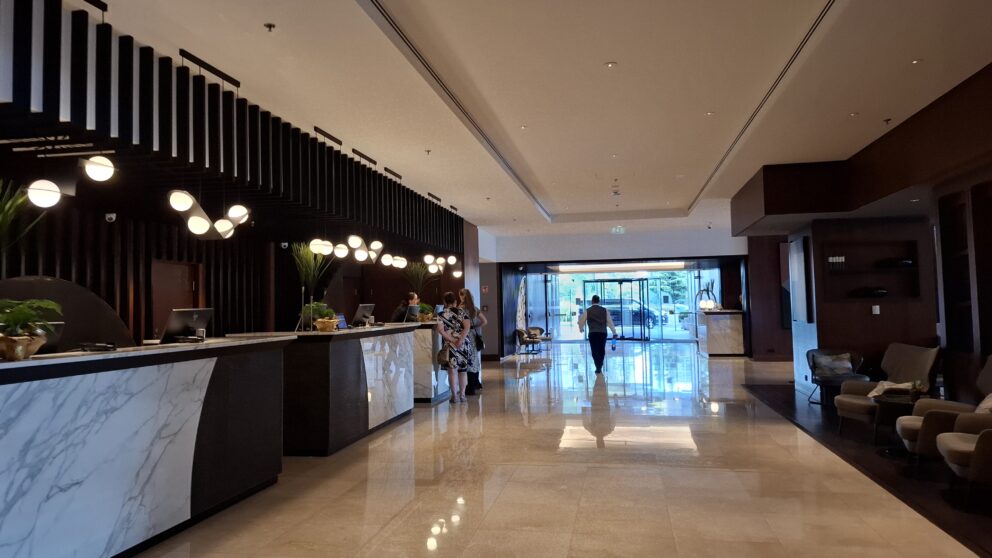 A highly comfortable modern bedroom featuring elegant warm lighting and a large glass door leading to a balcony