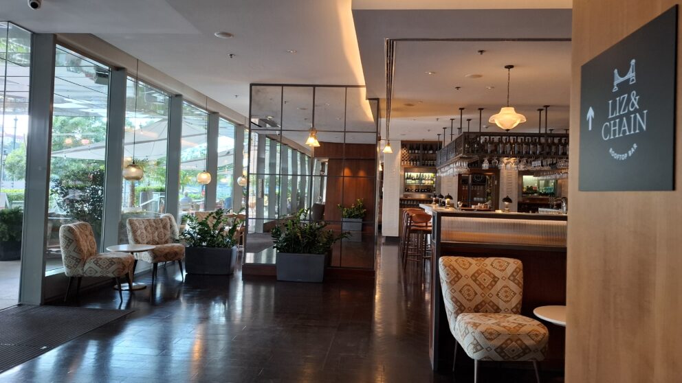 A standard comfortable bright hotel room showcasing a pristine white bed positioned perfectly to view the passing boats