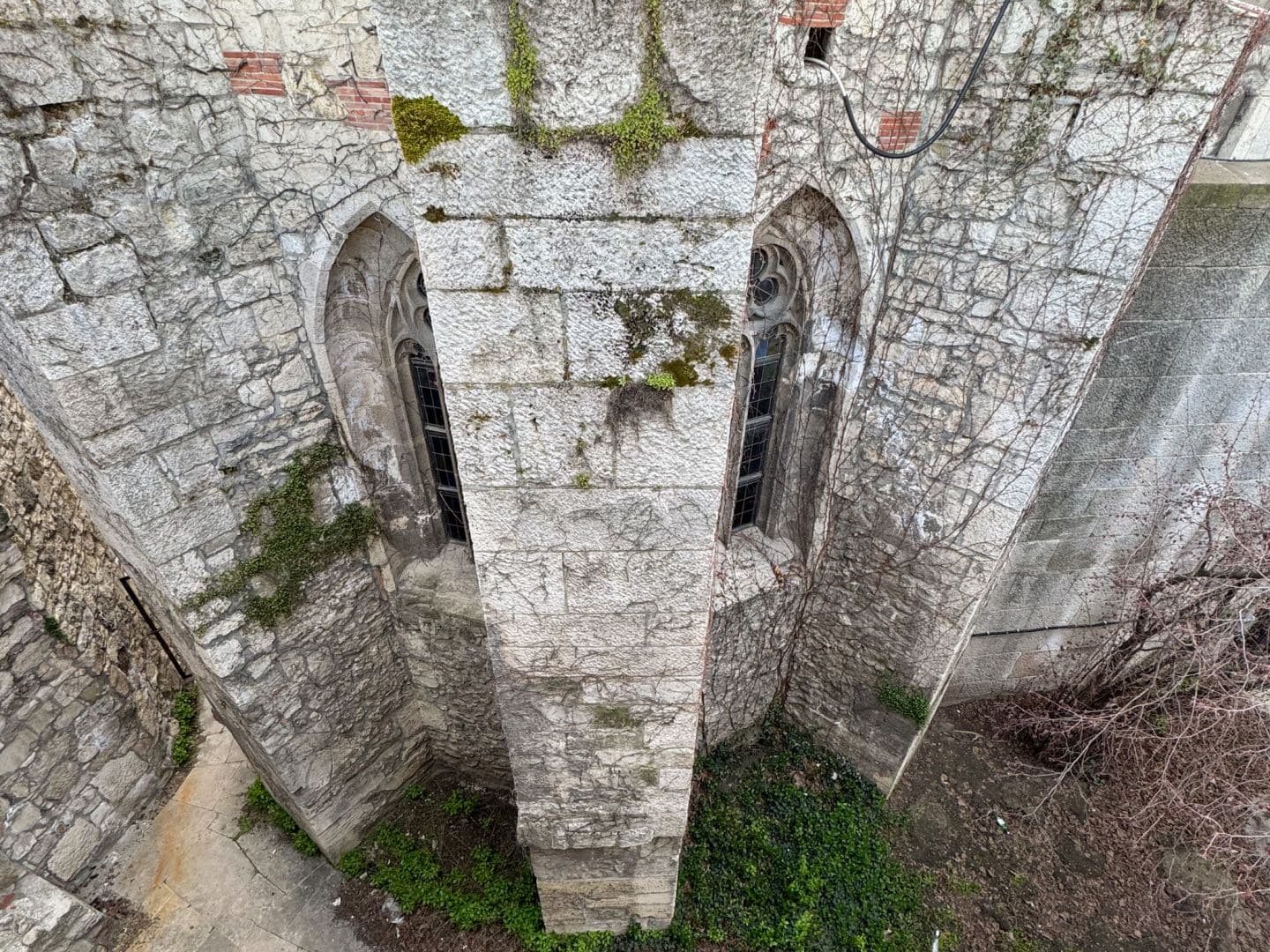 Rugged exterior stone walls of Matthias Church covered in ivy and moss