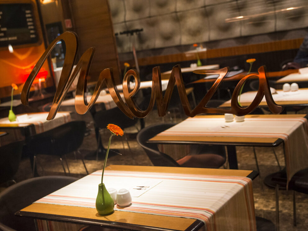 The iconic retro interior of Menza Restaurant viewed through the window