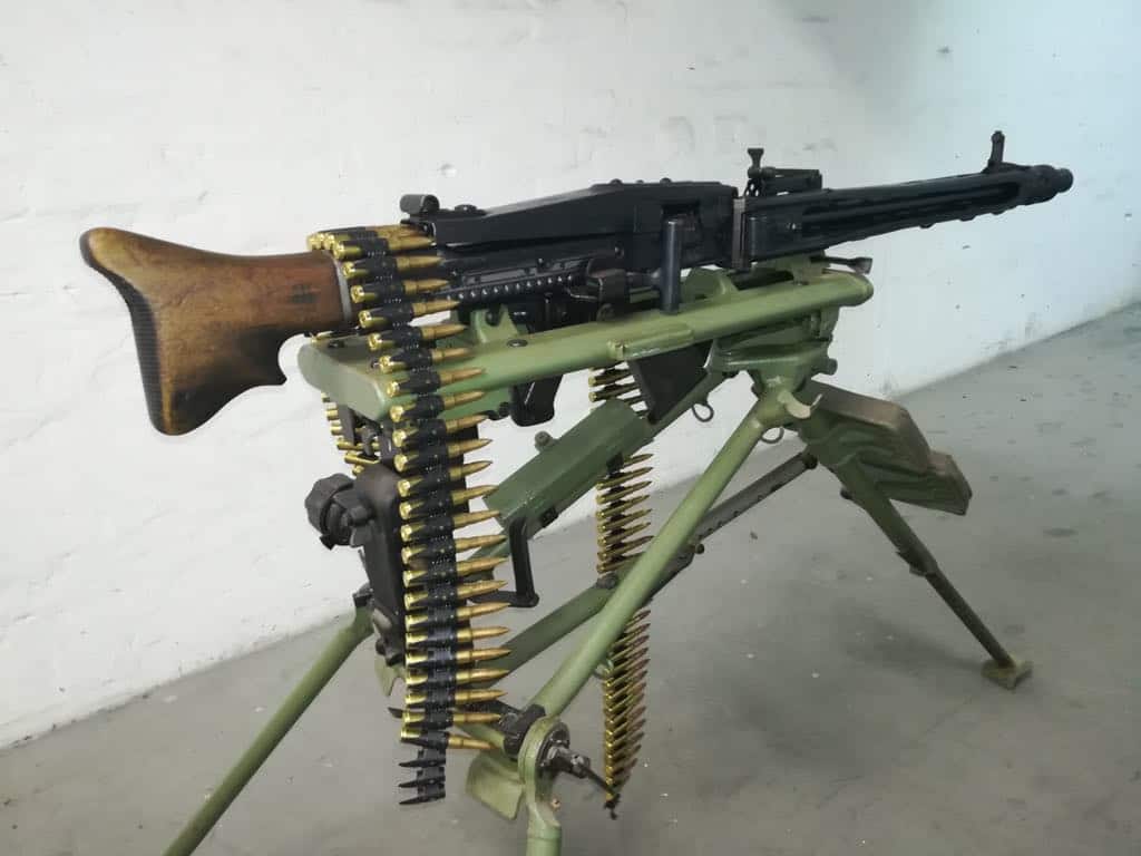 A German MG-42 machine gun mounted on a heavy tripod with a loaded ammo belt