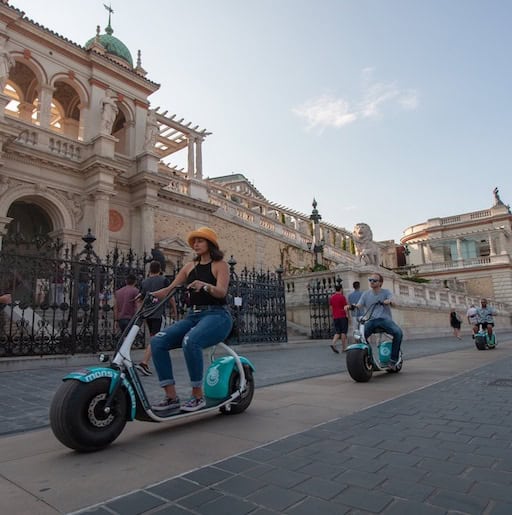 Tourists riding fat-tire MonsteRoller electric scooters near Varkert Bazar