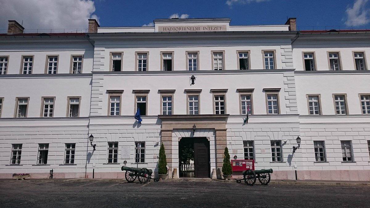 The classical white facade of the Museum of Military History in Budapest with two cannons at the entrance