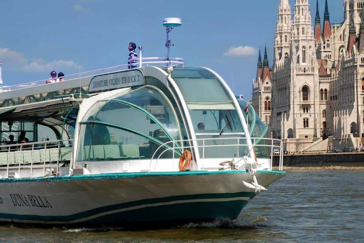 Cruising in a boat directly underneath the brilliantly illuminated Chain Bridge at night