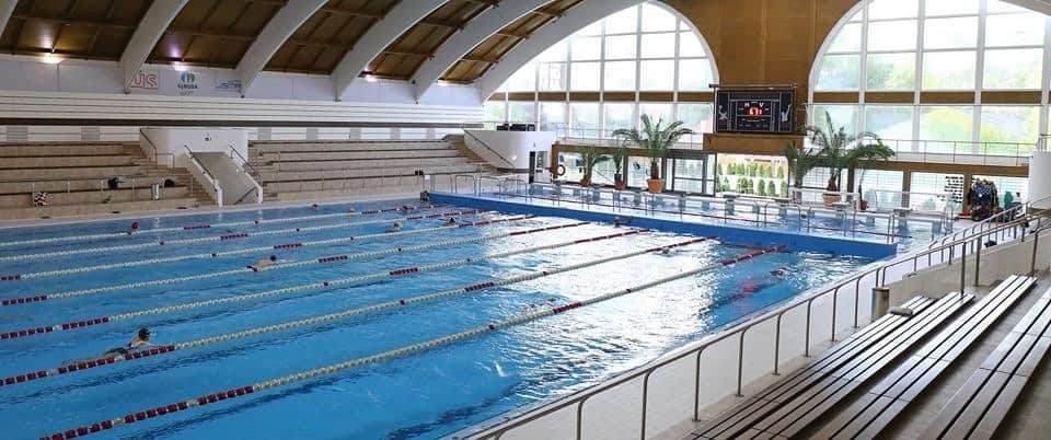 The indoor swimming pool at Nyeki Imre Uszoda with its wide wooden architectural arches