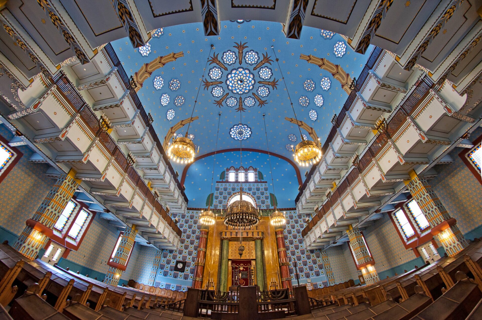 Detailed view of the painted blue ceiling and chandeliers inside the synagogue