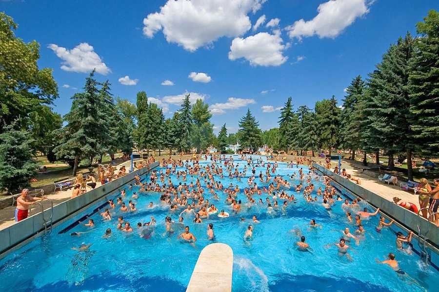 A woman swimming underwater in a clear bright blue pool at Palatinus Baths
