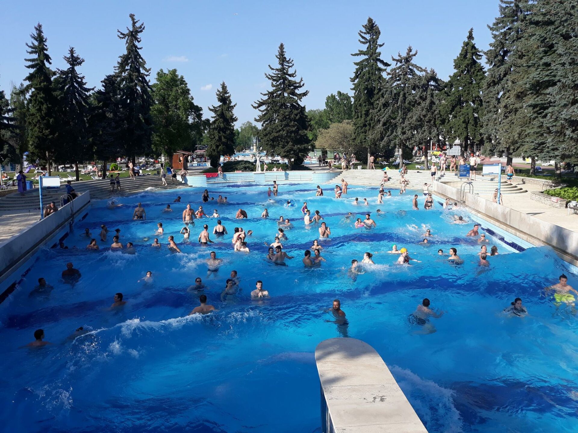 A massive wave pool full of people jumping in the surf