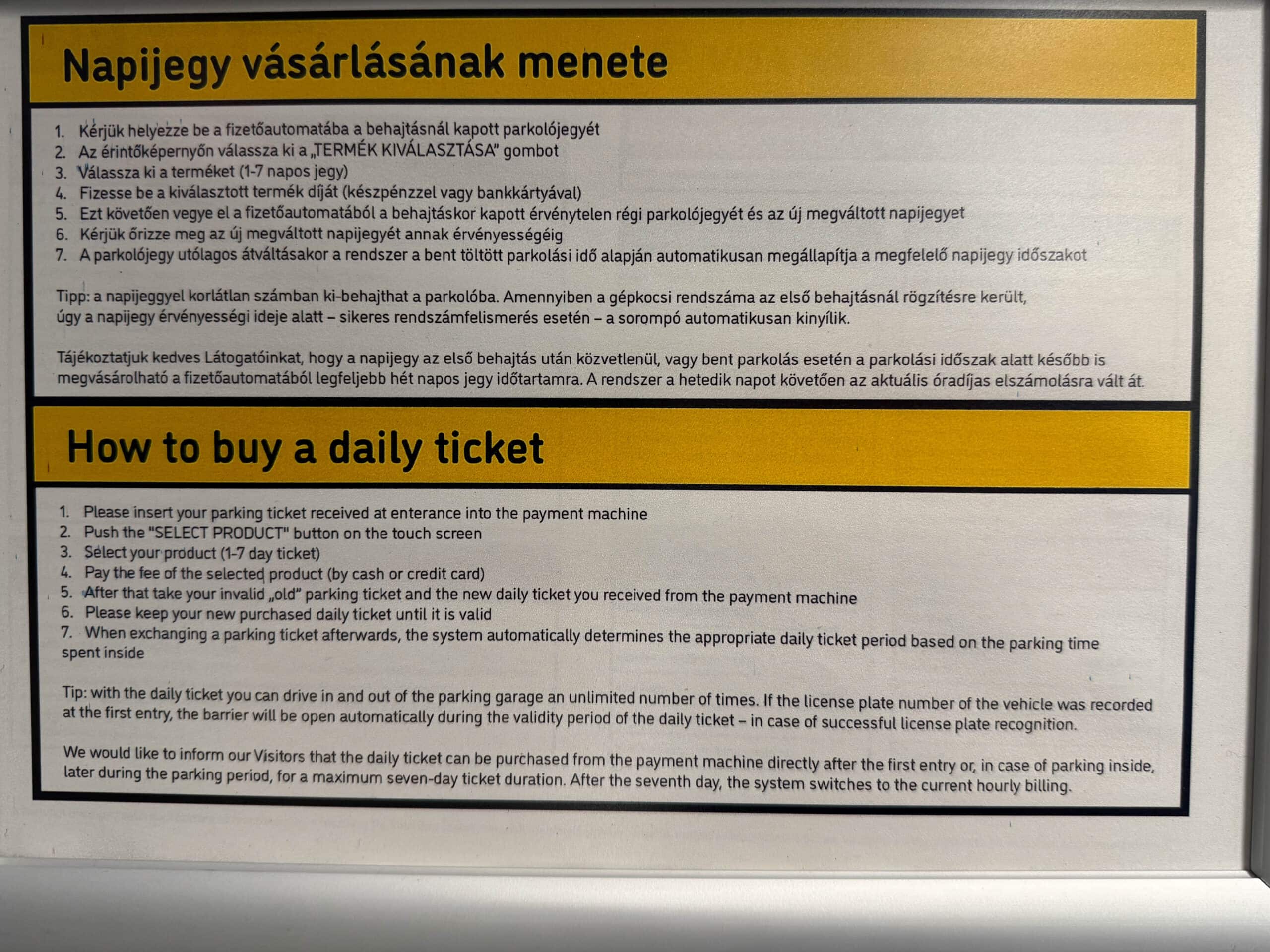 A bilingual informational sign panel detailing instructions on how to buy a daily parking ticket