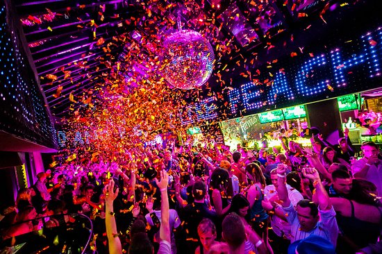 A massive crowd dancing under a shower of golden confetti at Peaches and Cream Club