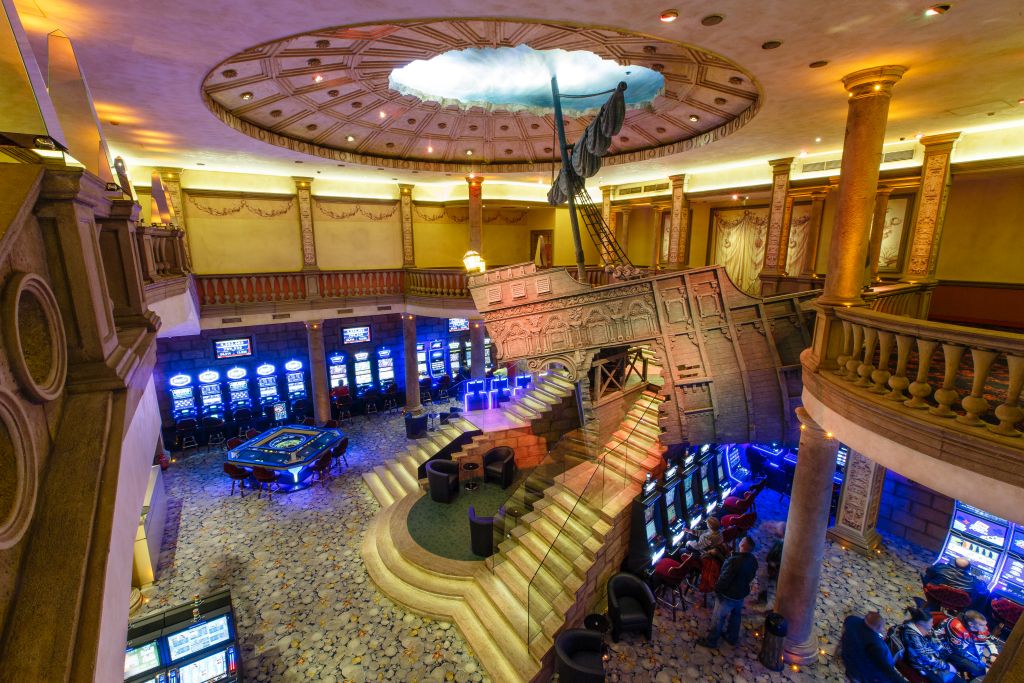 A professional poker dealer distributing cards at a casino table