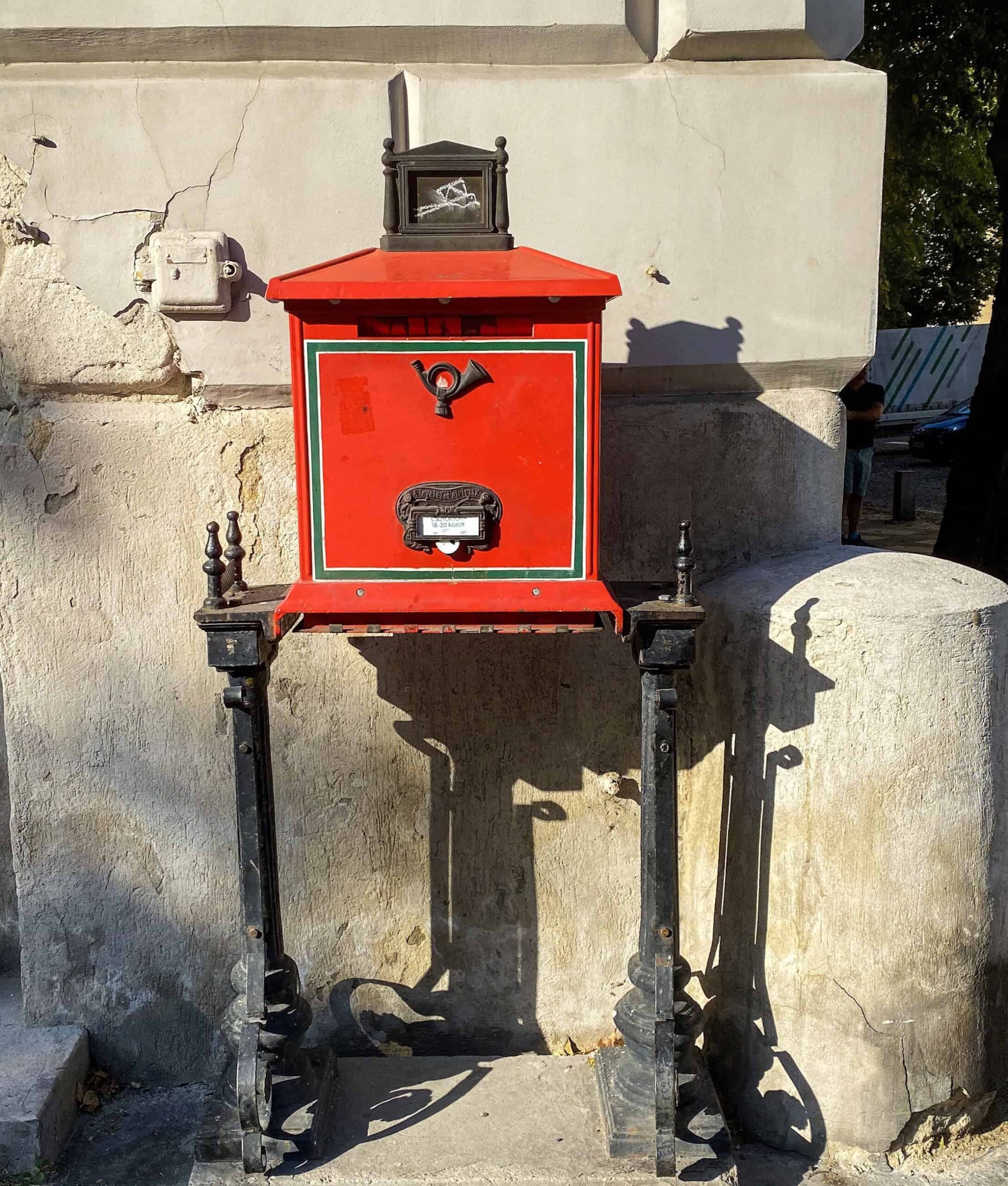 A post office sign and red letterbox near St. Stephen's Basilica