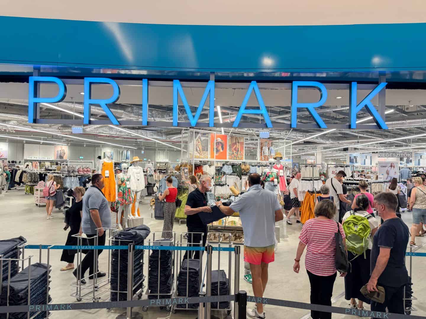 The iconic blue Primark sign above the bustling store entrance in Budapest