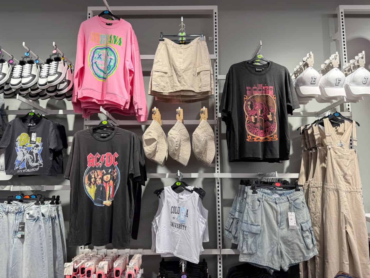Colorful graphic tees and band shirts displayed alongside shorts and skirts