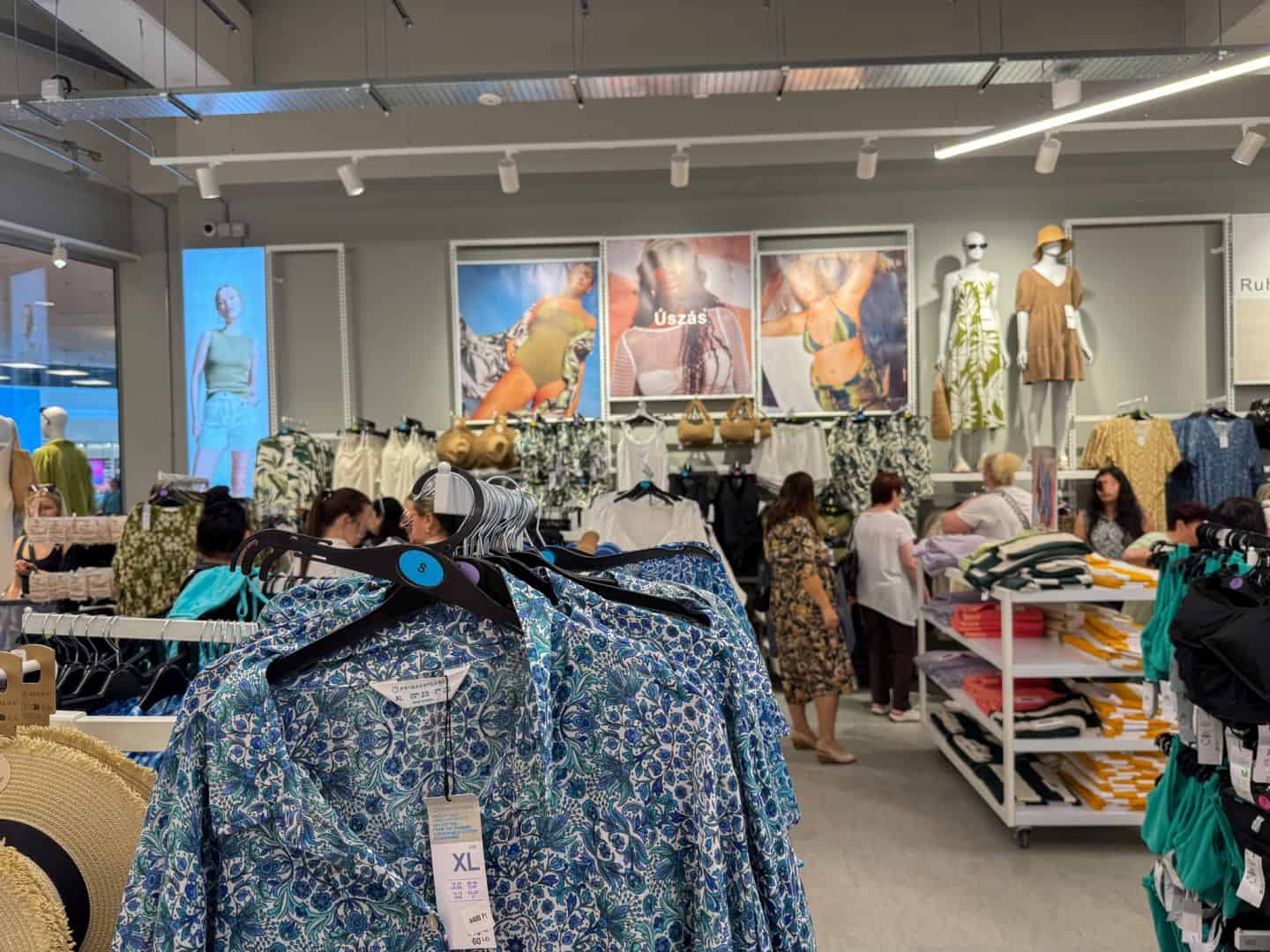 Racks of colorful bikinis and printed beach cover-ups in the swimwear section