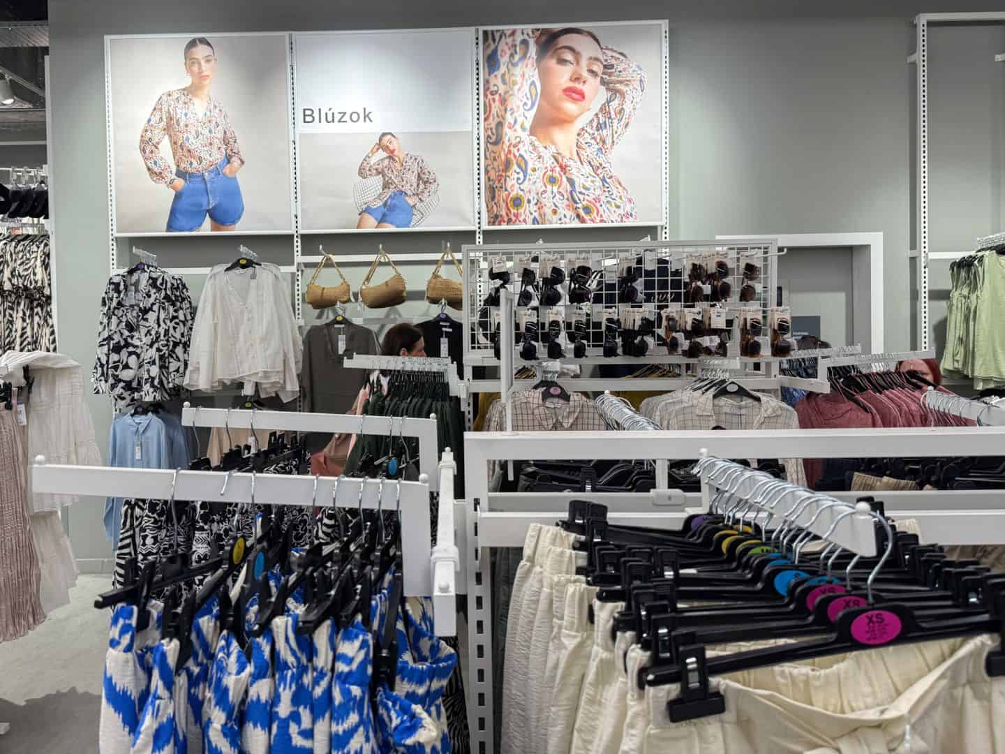 Racks of elegant women's blouses and summer pants at Primark