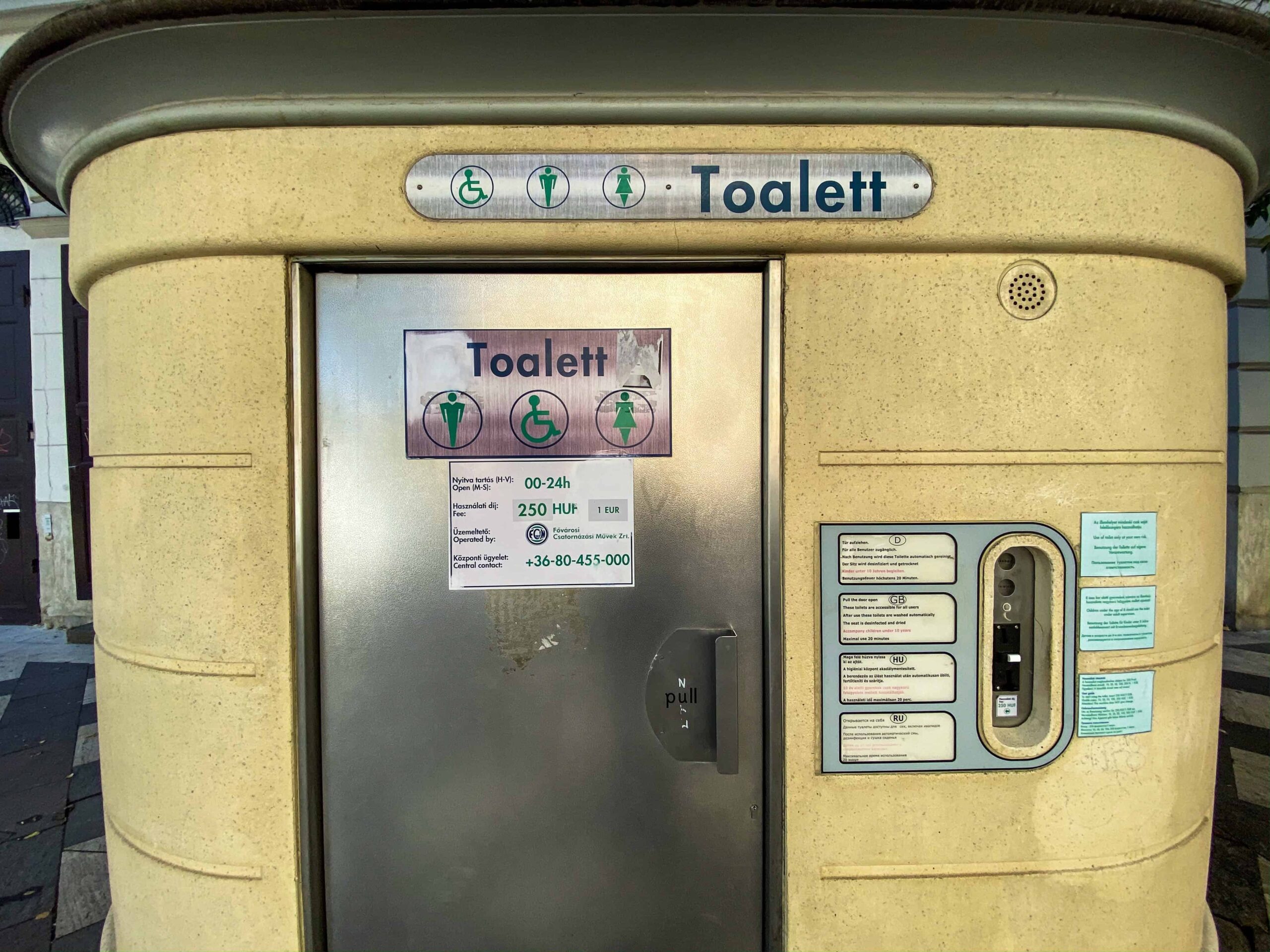 Printed user instructions and pricing details on a public toilet door