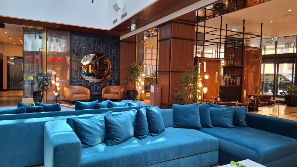 Plush blue velvet sofas in the modern lobby of the Pullman Budapest Hotel