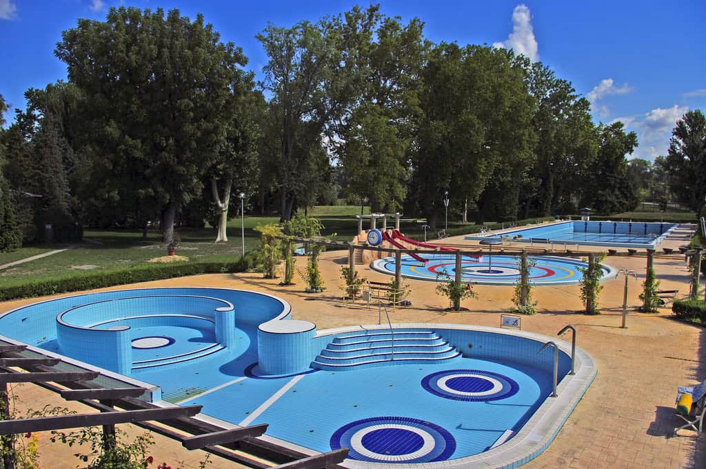The pristine, bright blue empty pools of Punkosdfurdo Bath surrounded by trees