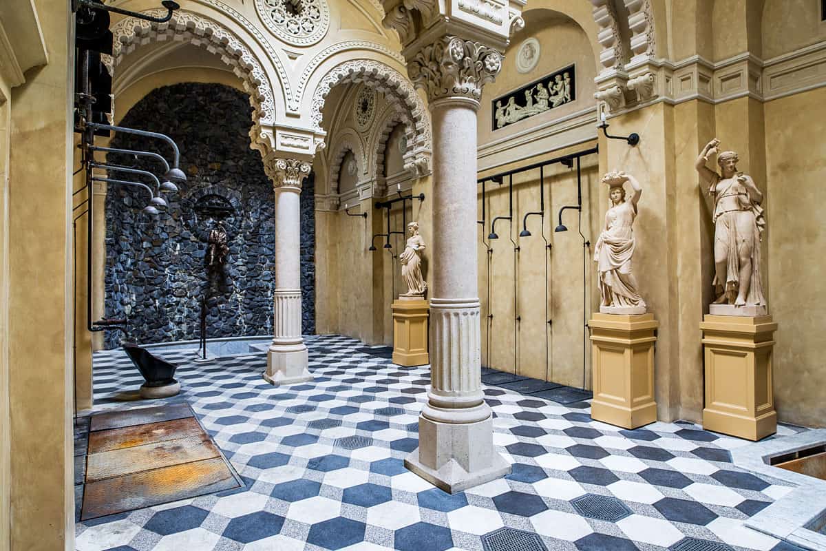 Beautifully restored interior hall of the Rac bath featuring statues and showers