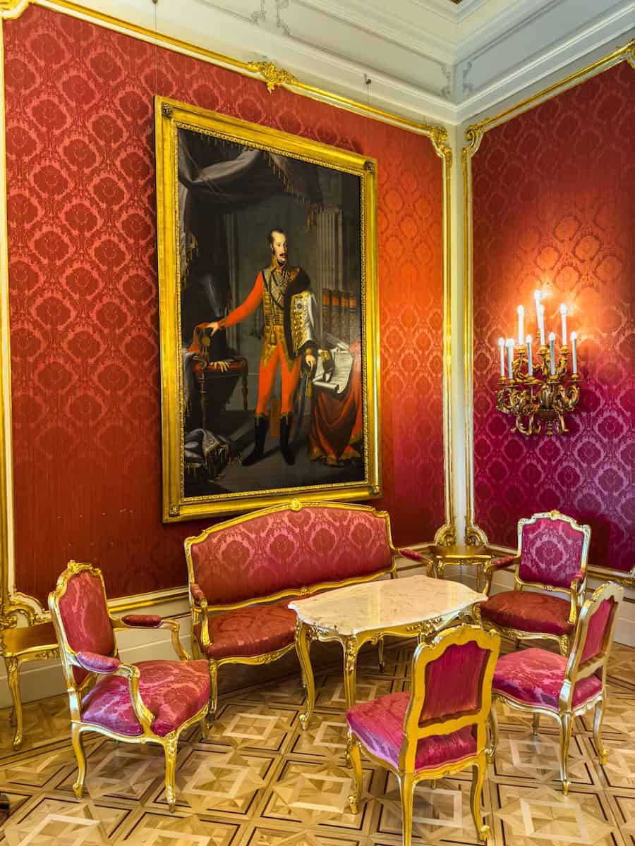 Red velvet gilded chairs matching the red walls in the Red Salon