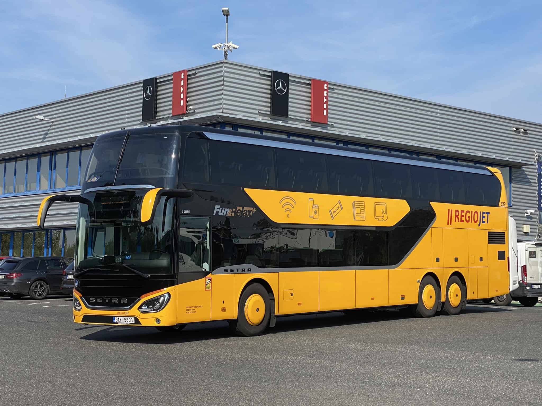 A bright yellow RegioJet coach bus arriving in Budapest to travel to Vienna