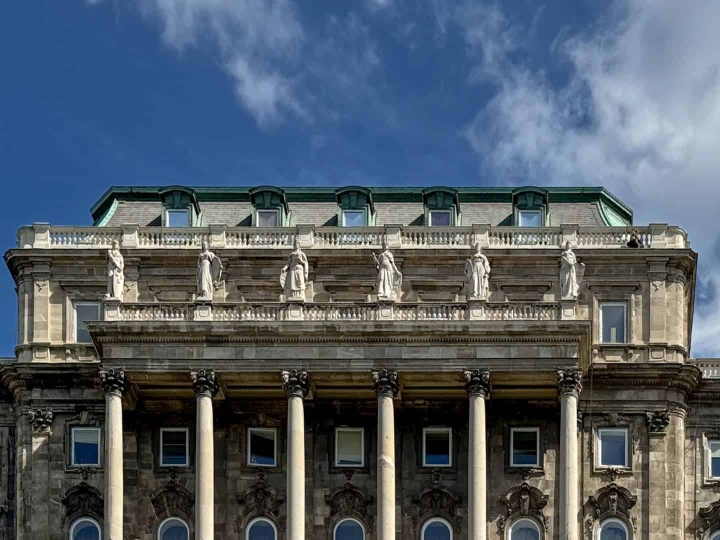 Six classical female statues adorning the upper facade of the Royal Palace