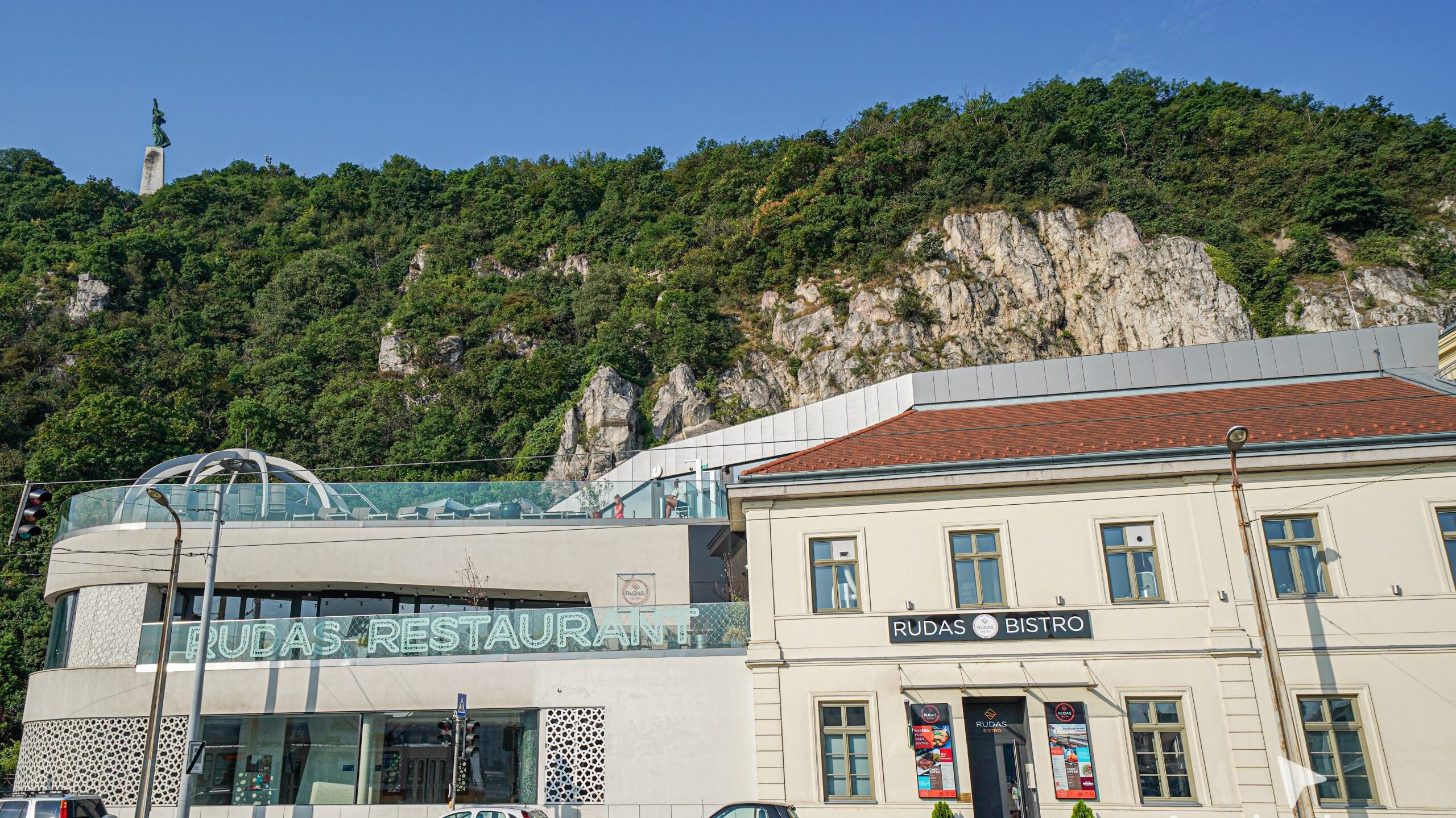 The classic historic stone facade and glass rooftop pool of the Rudas Baths
