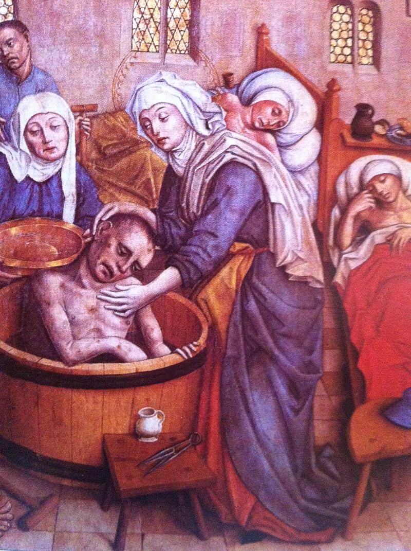 A medieval painting showing Saint Elizabeth bathing a sick man in a wooden tub