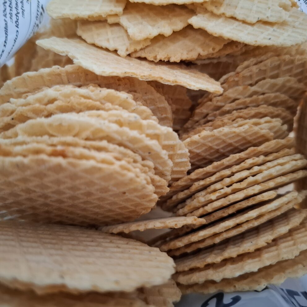 A stack of golden, checkered, deeply baked salty cheese wafers