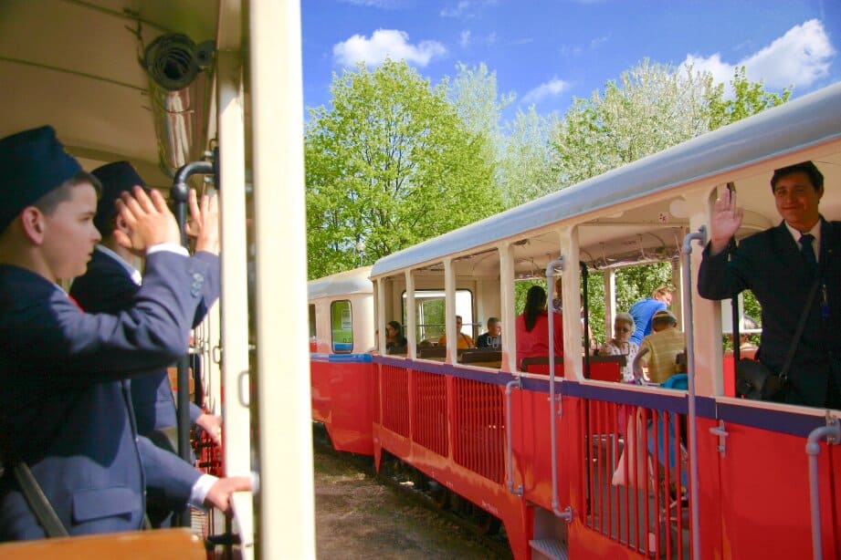 The Children's Railway moving across a ridge with views of Budapest in the background