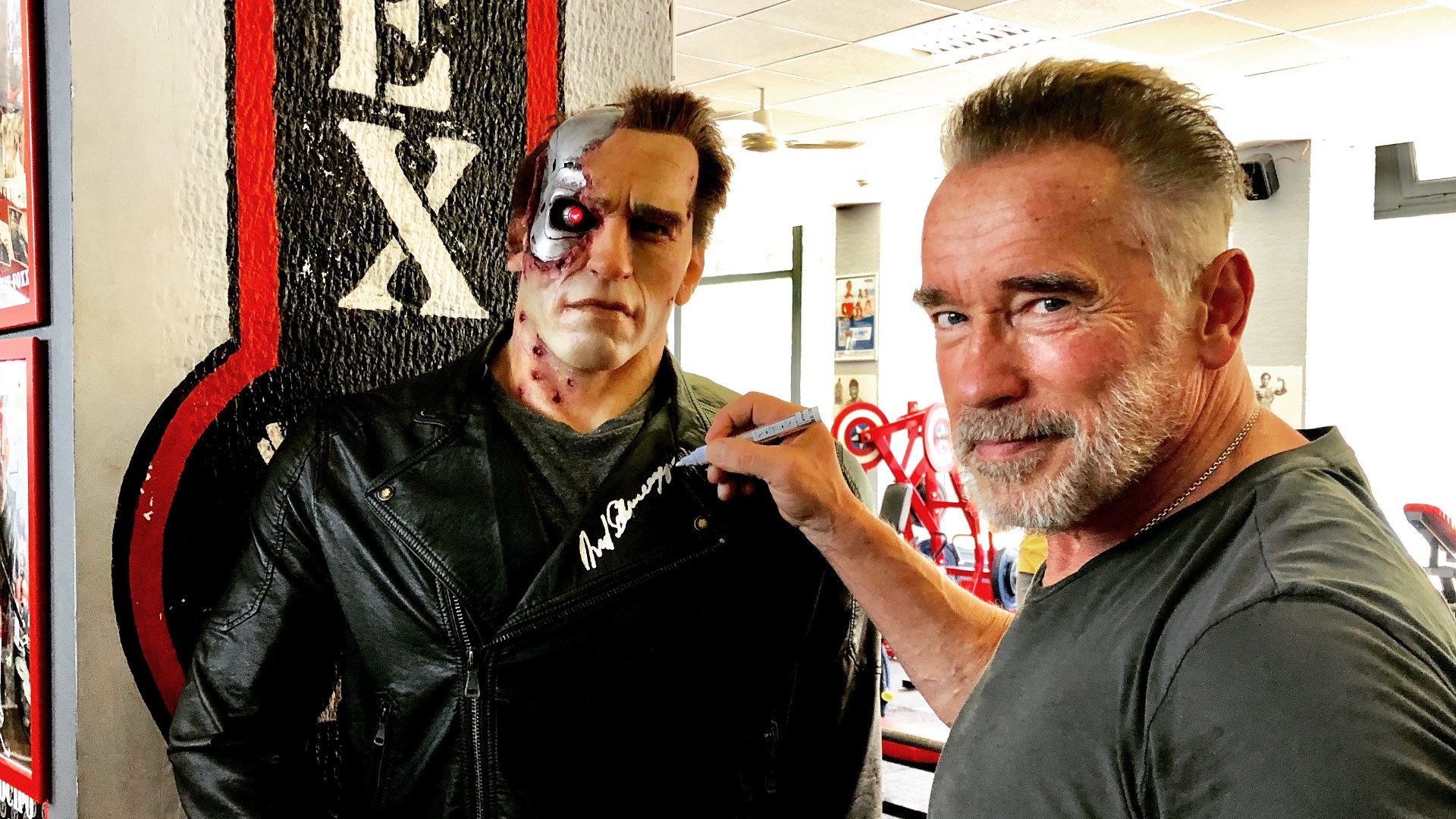 Arnold Schwarzenegger signing the Terminator statue in Flex Gym