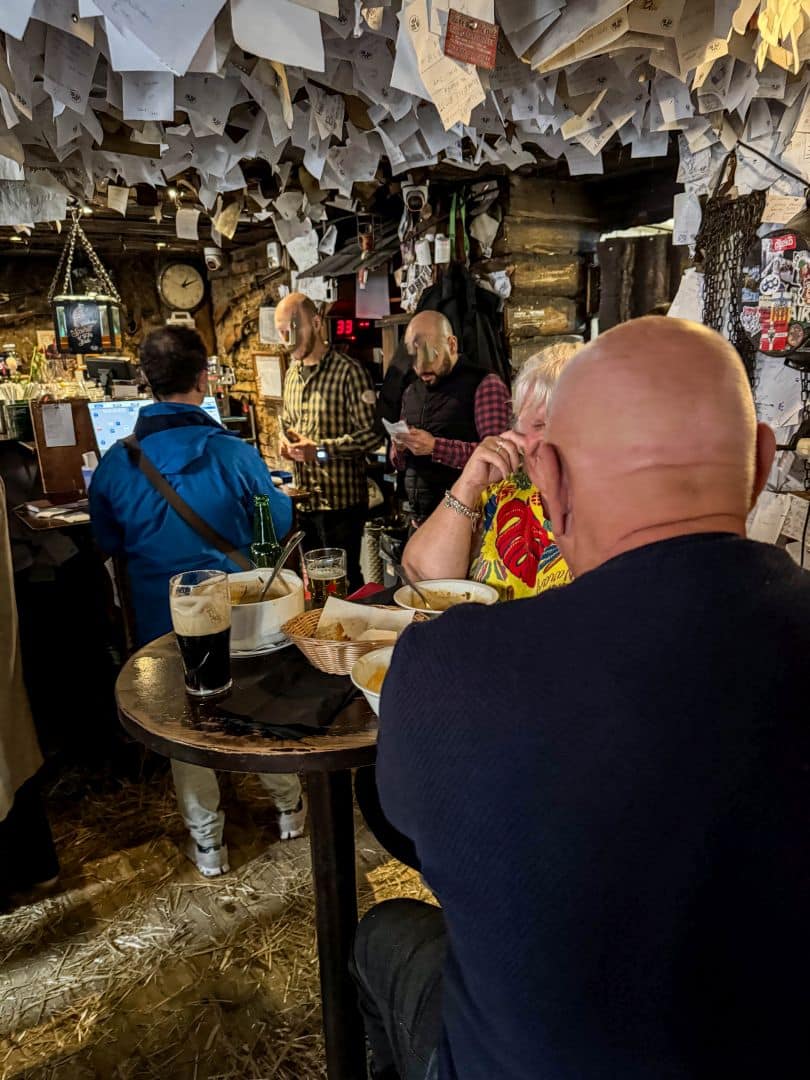 A small two-person wooden table featuring an overflowing basket of peanuts
