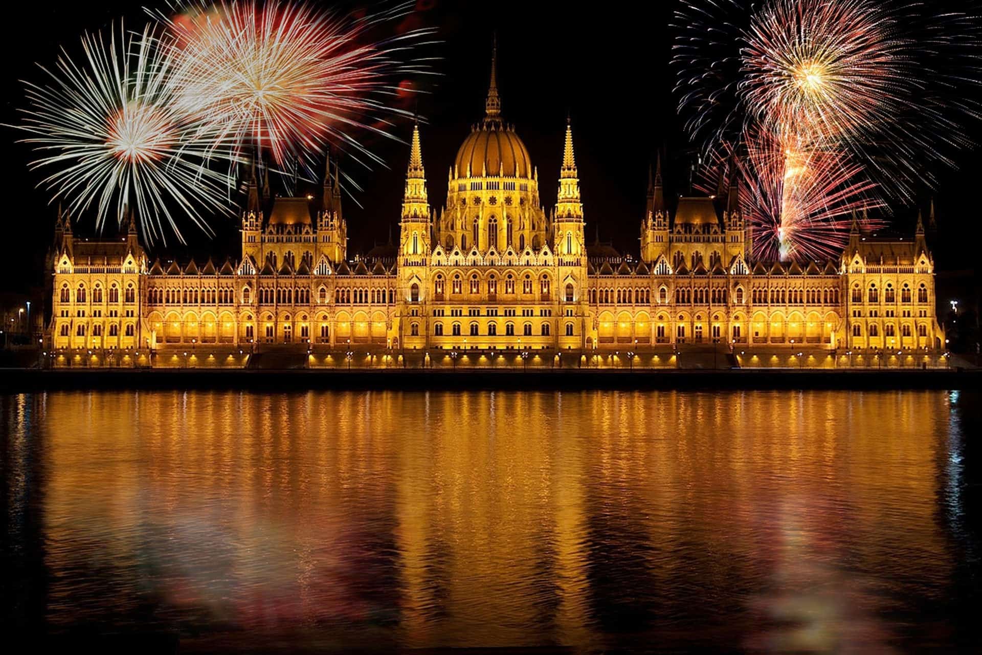 Spectacular fireworks exploding over the illuminated Hungarian Parliament building at night
