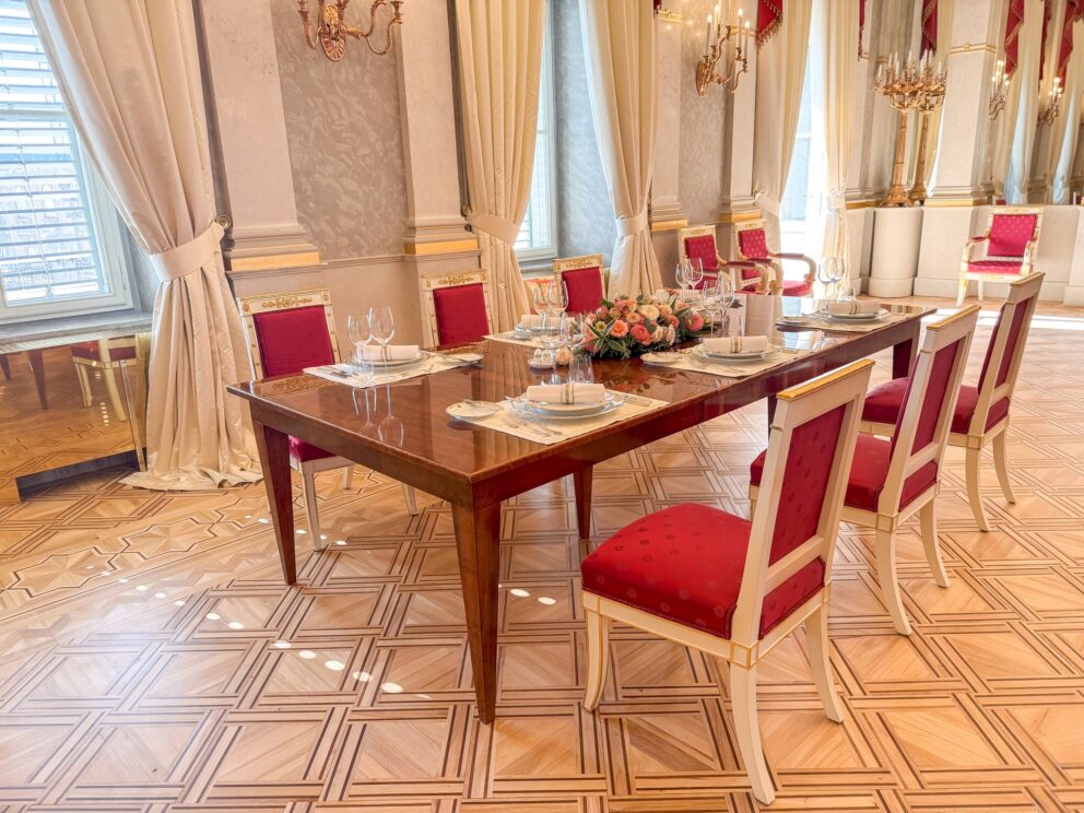 A long dining table set for a state banquet in the Hall of Mirrors