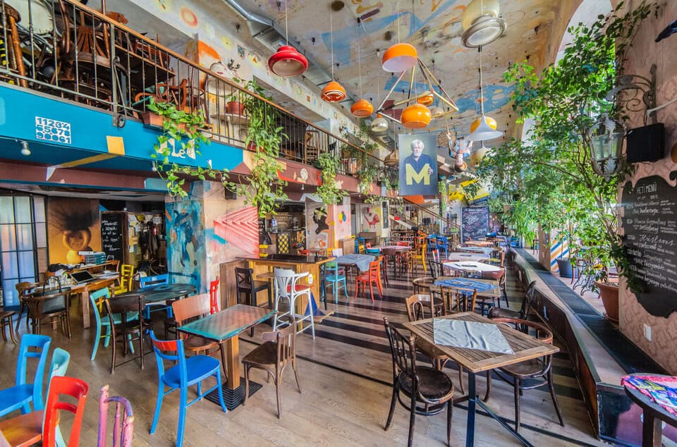 The vibrant, colorful, and chaotic ruin pub style interior of Szatyor Bar