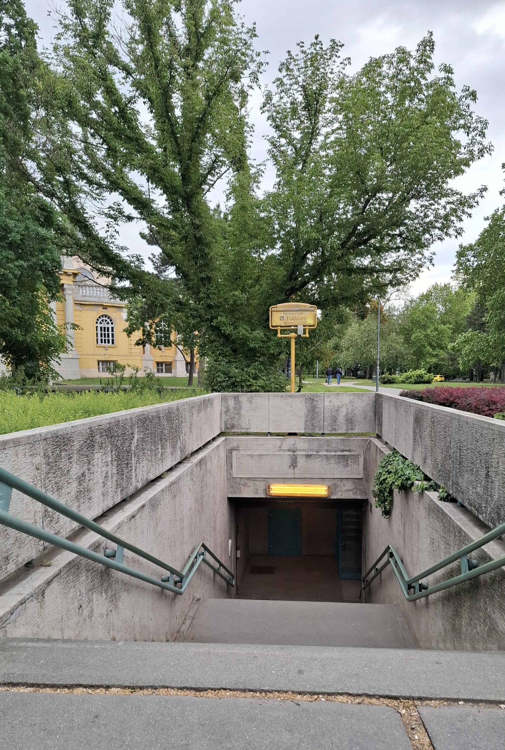 A clean shot of the yellow metro train arriving at the famous Szechenyi Thermal Bath destination station