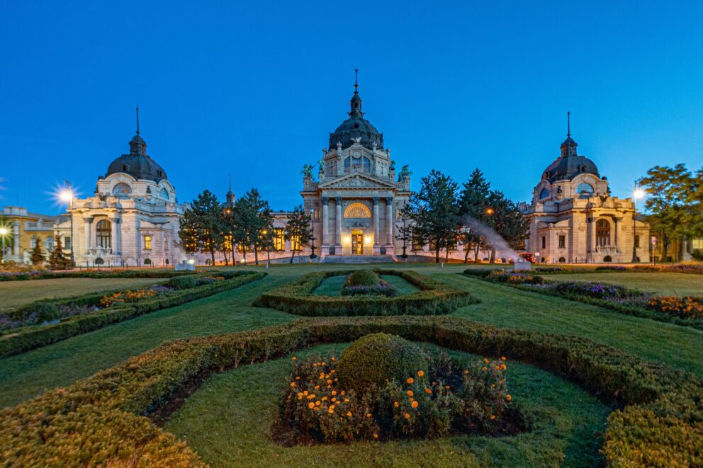 The vibrant yellow neo-baroque facade of the Széchenyi Baths in City Park