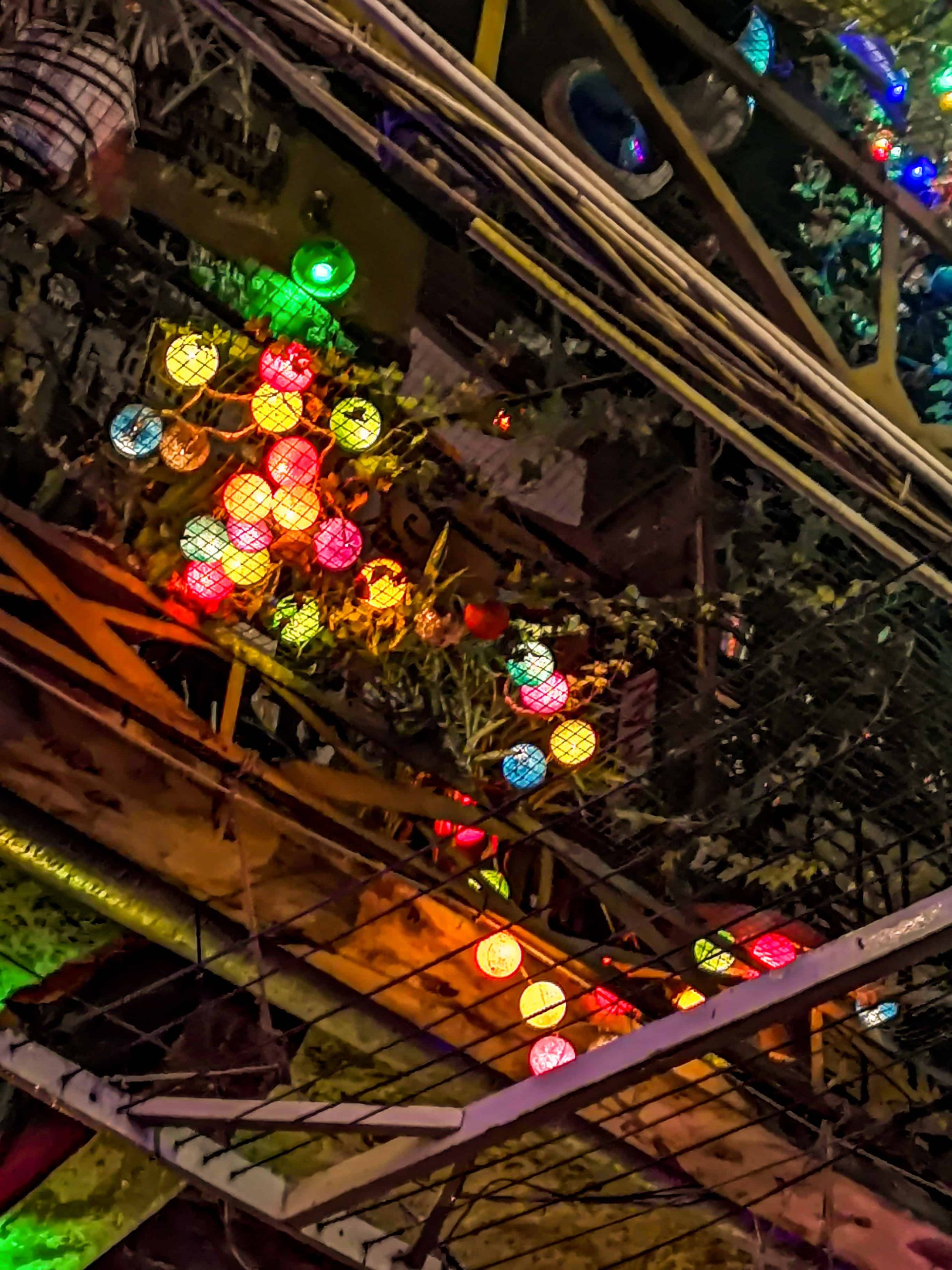 Colorful glowing lanterns strung across the courtyard ceiling at Szimpla