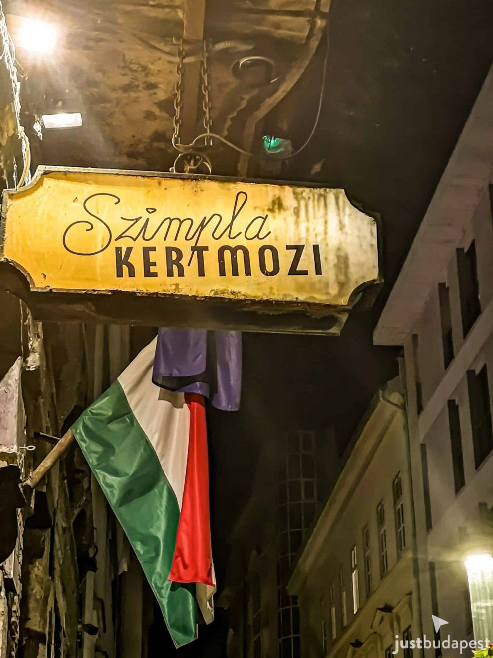 Vintage illuminated yellow sign for the Szimpla Kertmozi open-air cinema