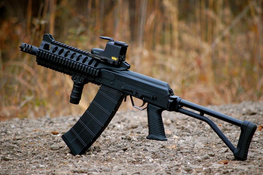 A highly modified Saiga-12 tactical shotgun with red dot sight and box magazine