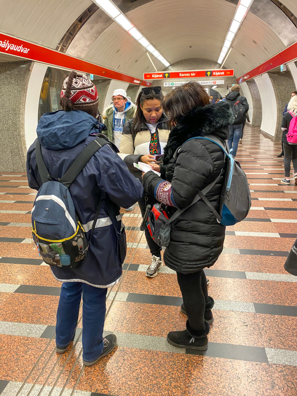 Ticket inspectors checking a passenger's digital pass on a phone