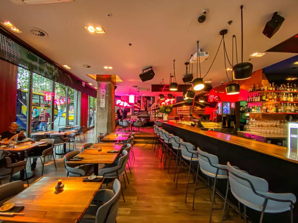The vibrant neon-lit interior and bar counter at TOKIO Budapest