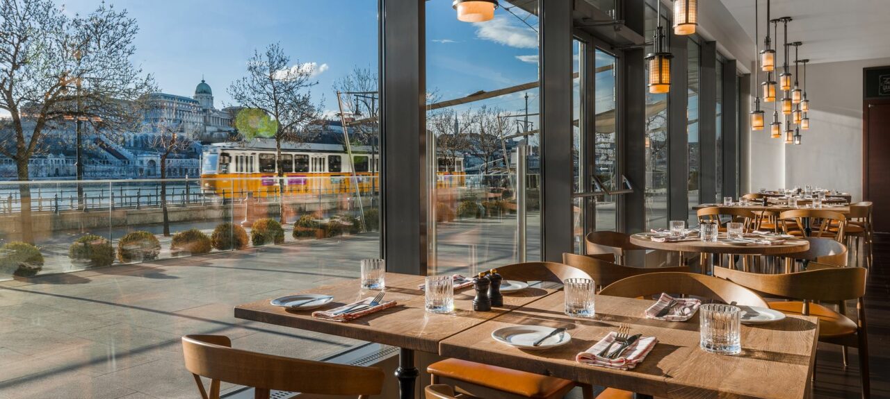 A rustic table setting featuring a steaming bowl of Chicken Paprikash and crusty bread