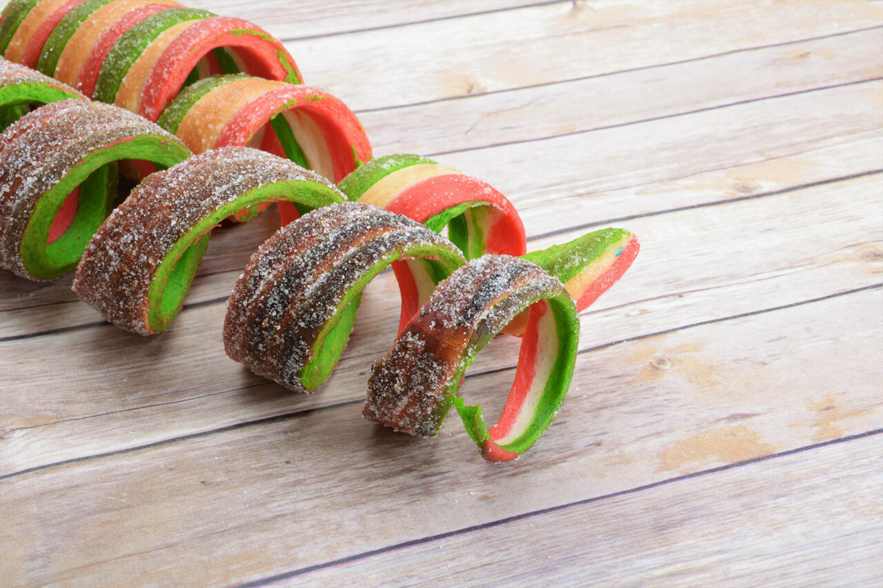 A busy chimney cake vendor stall roasting cakes at an outdoor market