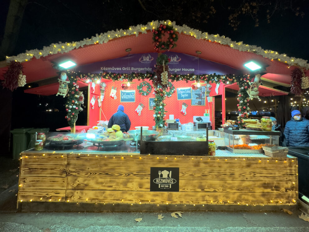 A highly decorated food stall serving hot meals at a Budapest Christmas market