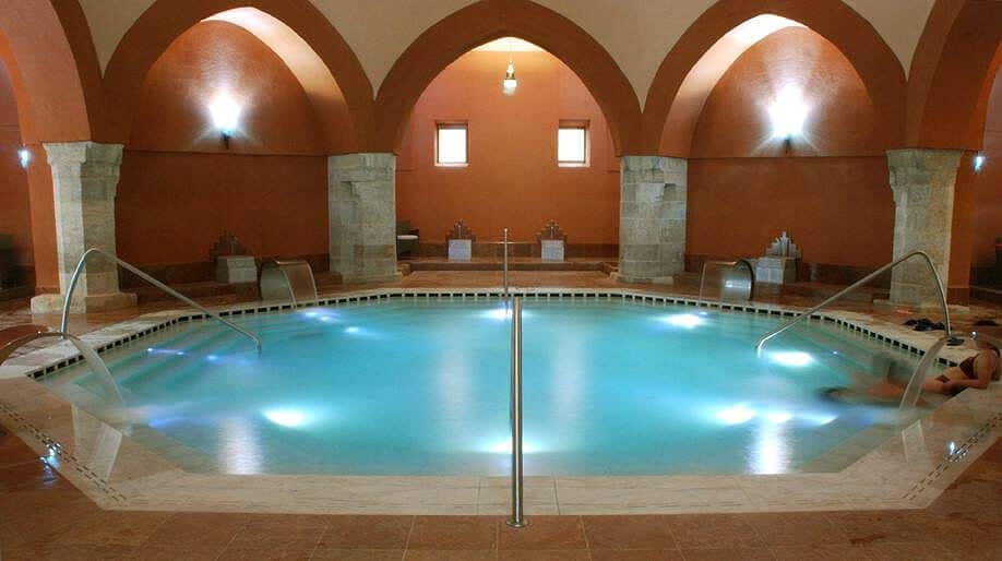 The thermal water glowing under the stone arches of Veli Bej