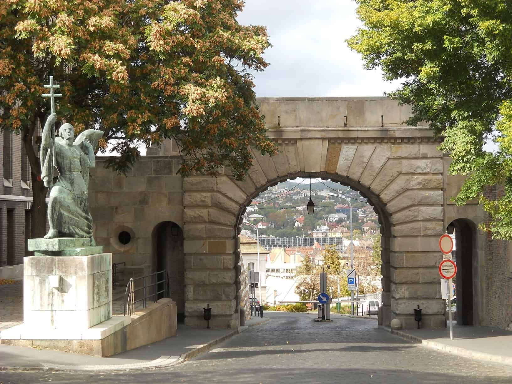 The historic stone Vienna Gate with a large bronze angel statue in the Buda Castle district