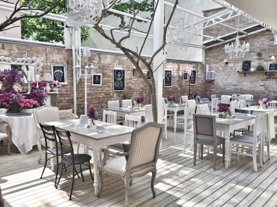 An elegant shabby-chic outdoor terrace decorated with lilacs and chandeliers