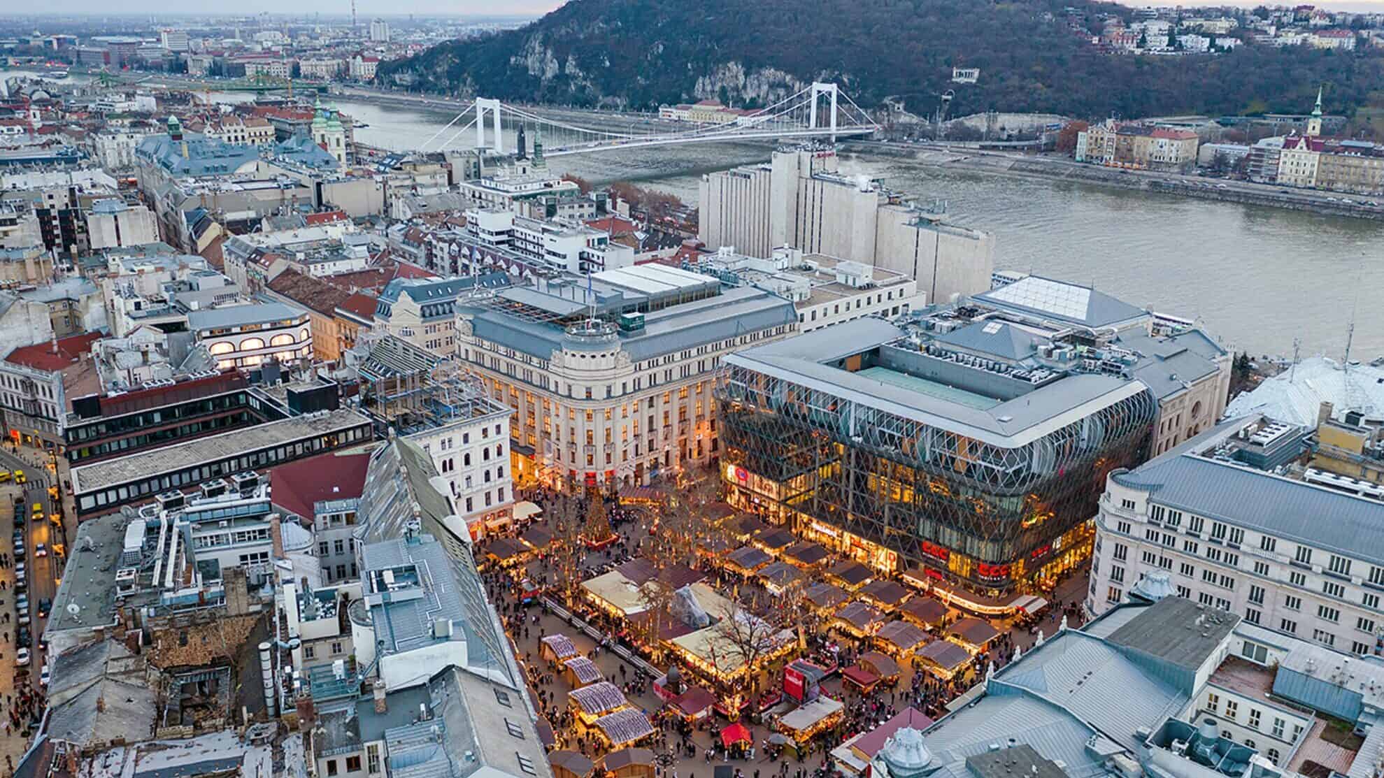 Visitors exploring the artisanal stalls at the Vörösmarty Square Christmas market